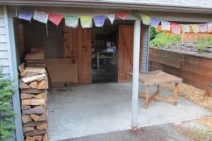 Covered back patio next to the enclosed storage and work shop